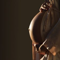 Beautifil Silhouette of a pregnant woman with highlight on belly copy space